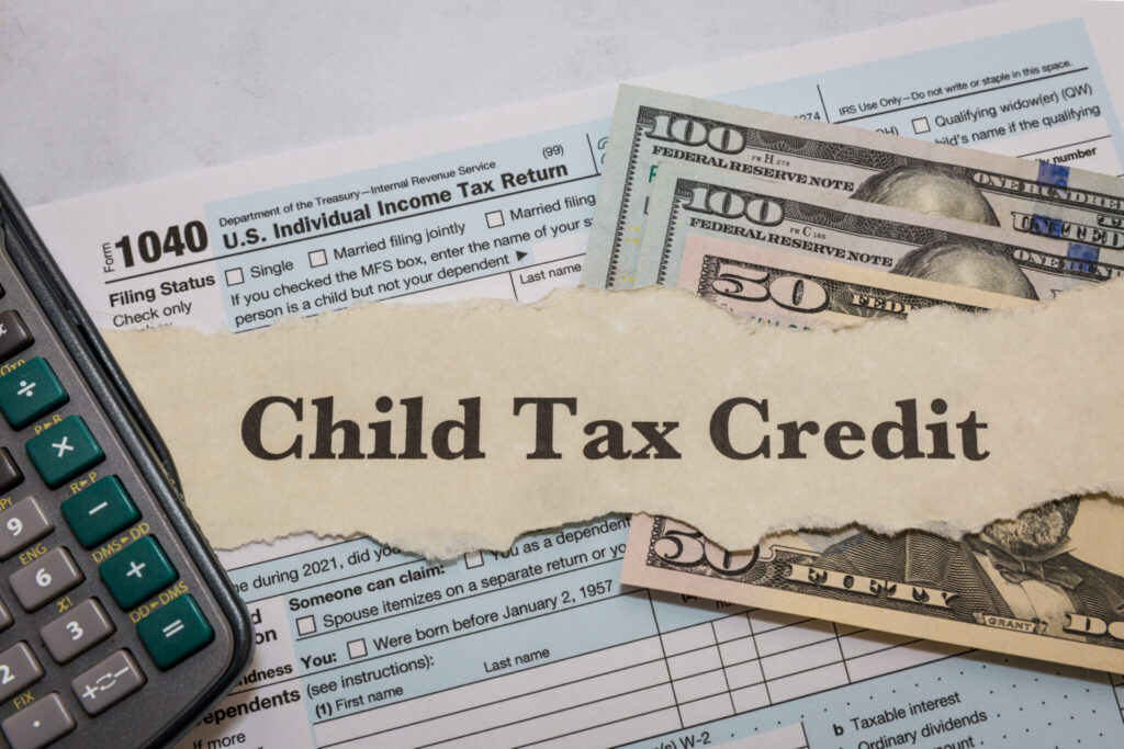 child tax credit typed on paper with 1040 irs form, calculator, and dollar bills child tax credit typed on paper with 1040 irs form, calculator, and dollar bills